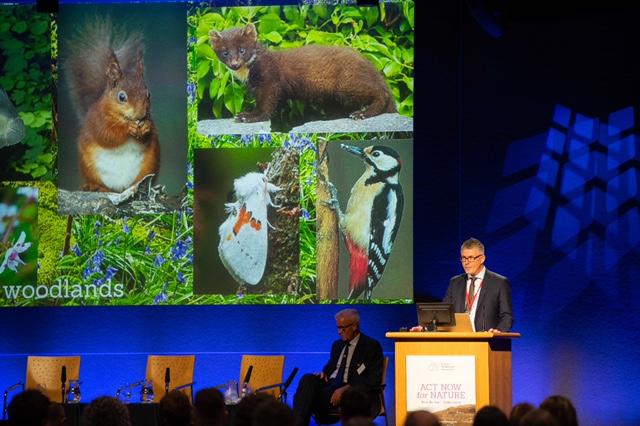 Man speaking at a conference podium.