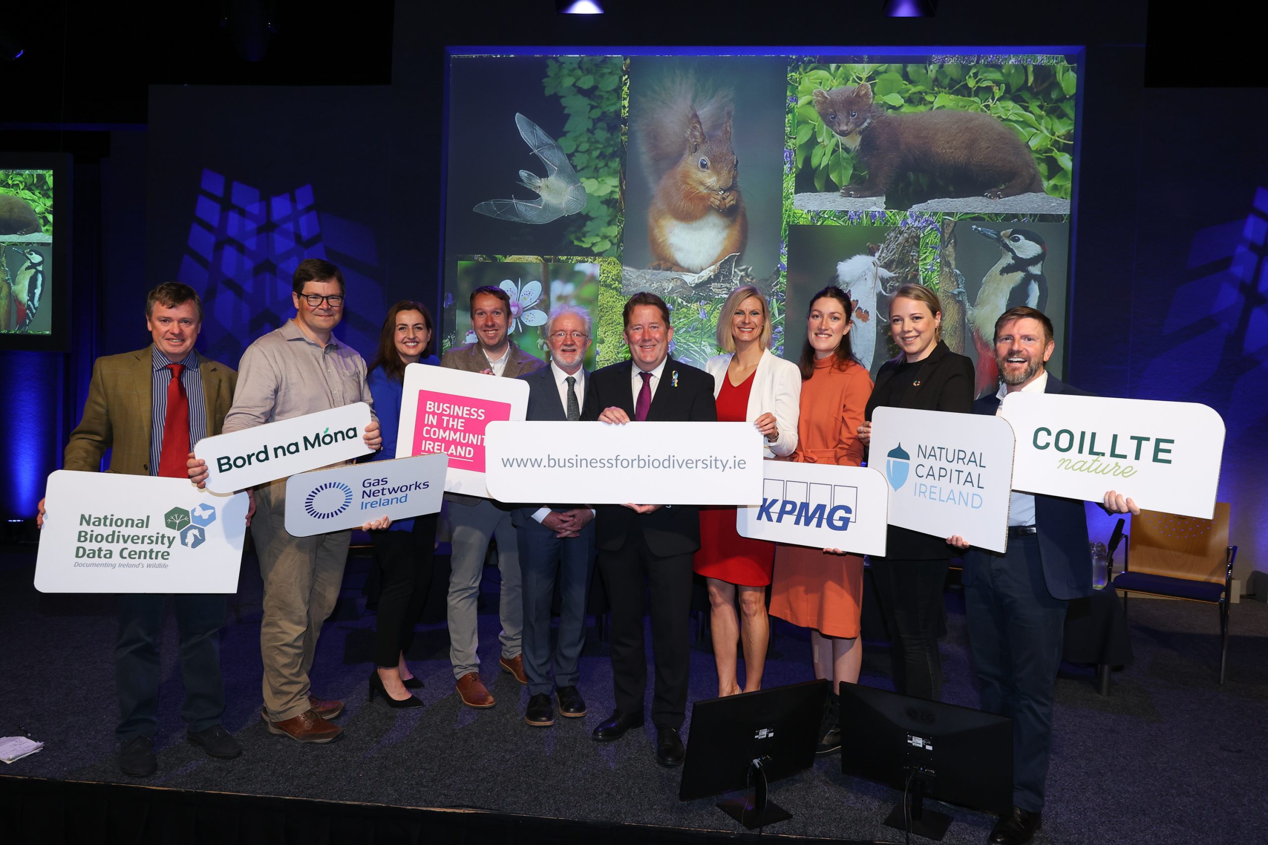 Ministers and attendees holding a logo banner.