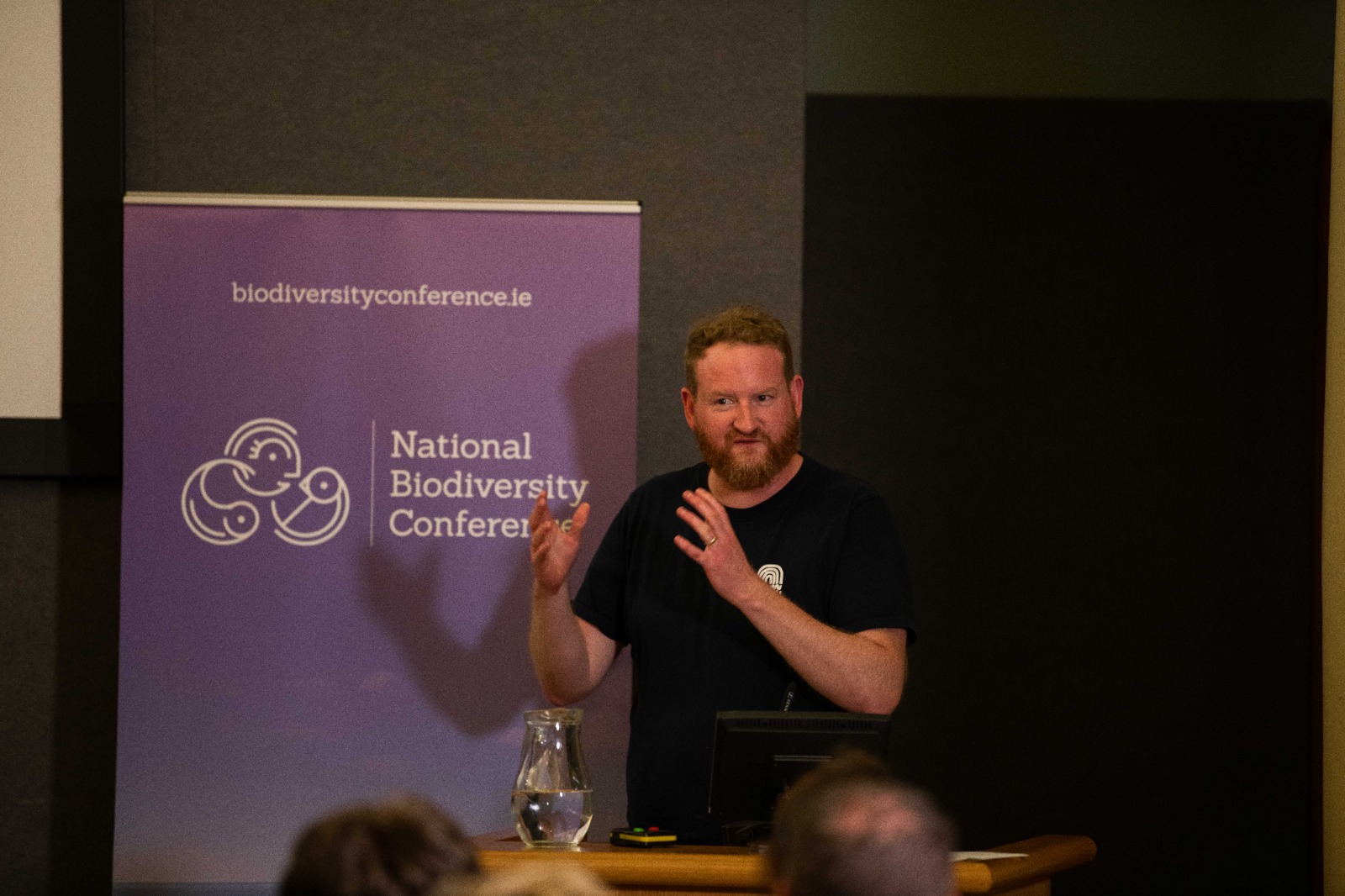 Man speaking at a conference podium.