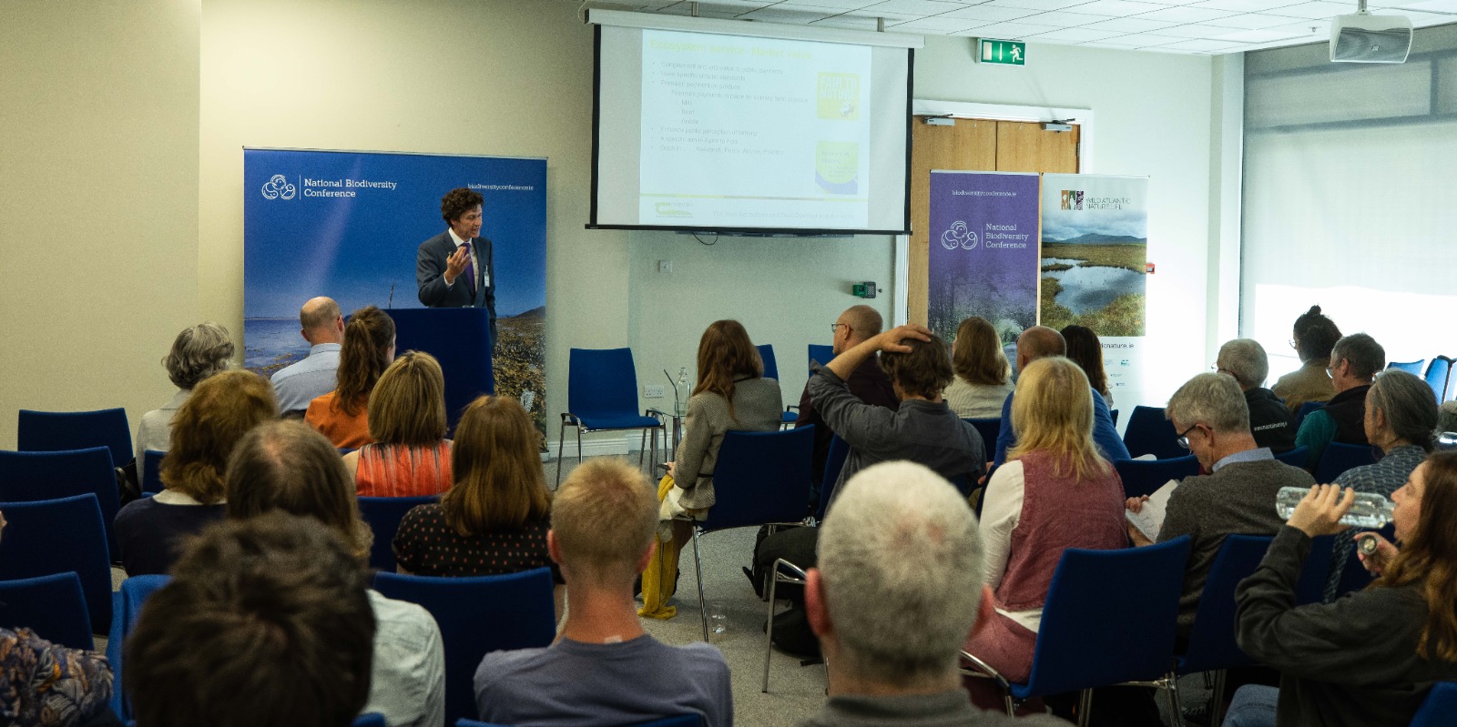 Man speaking at a conference podium.