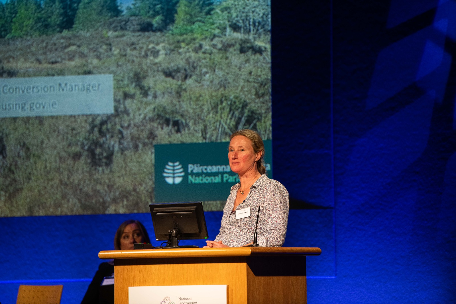 Woman speaking at a conference podium.