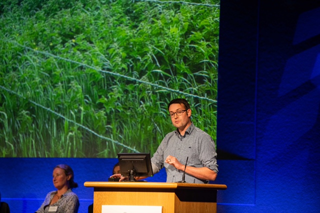 Man speaking at a conference podium.