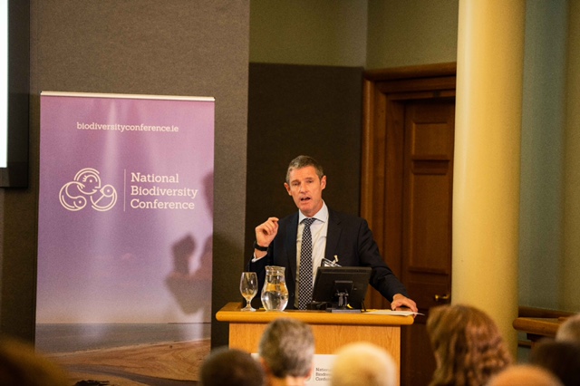 Man speaking at a conference podium.