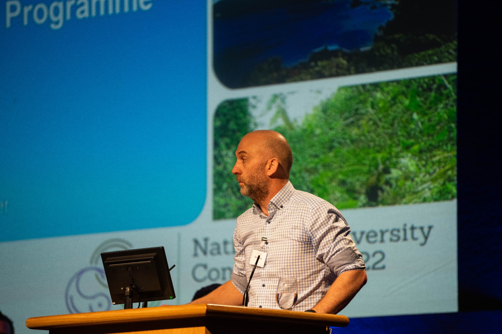 Man speaking at a conference podium.