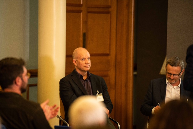 Attendees listening to a speaker at a conference.
