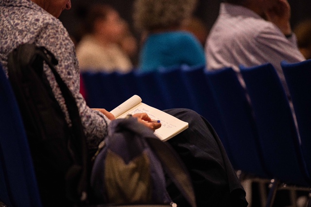 Participant writing notes at a conference.